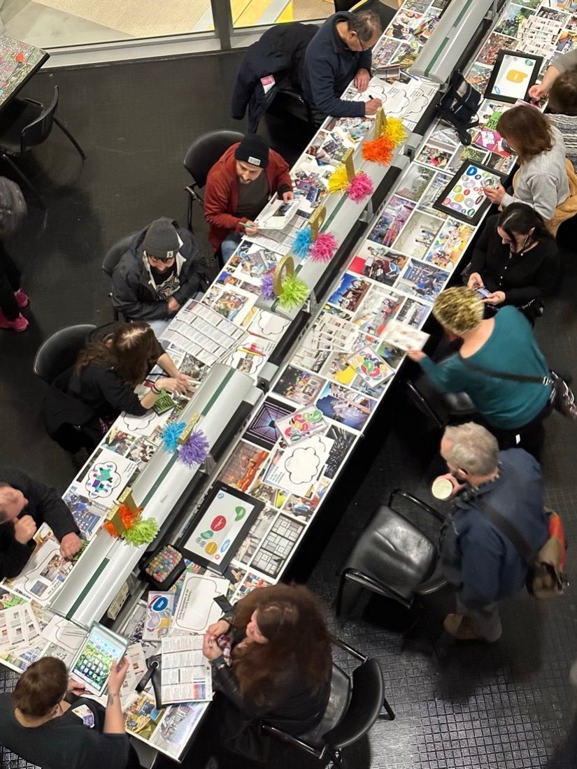 Community members sit at a long table craft the future of the city and SFPL narratives with paper and illustrations during the March 2023 Night of Ideas